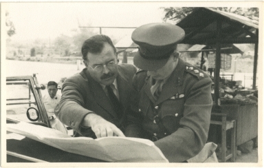 Hemingway Pointing to Document Held by Man in Army Uniform