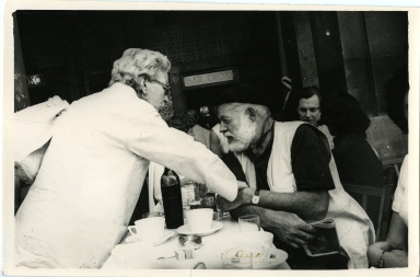 Hemingway Seated at Spanish Restaurant, Holding Hands with Woman