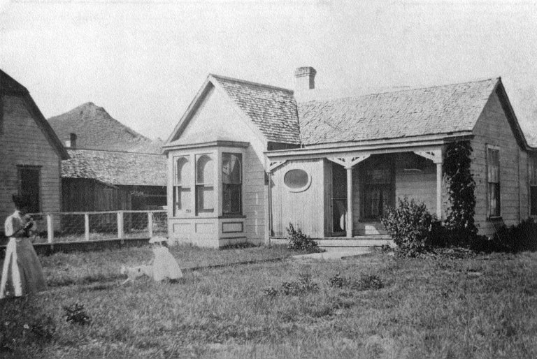Early residents in front of a house.